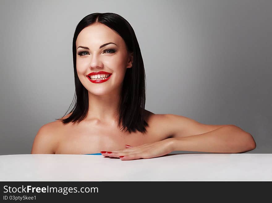 Portrait of a happy young woman smiling against grey background. Portrait of a happy young woman smiling against grey background