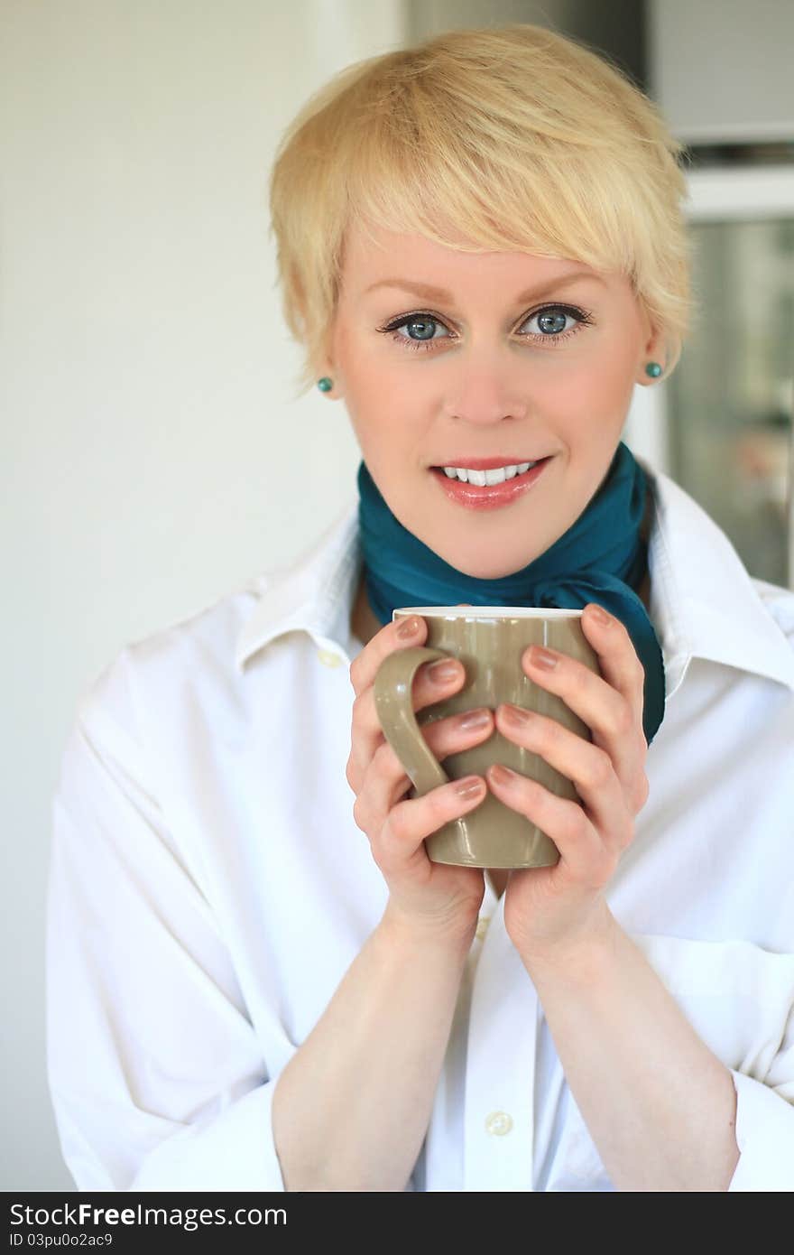 A young happy woman having a nice cup of coffee. A young happy woman having a nice cup of coffee