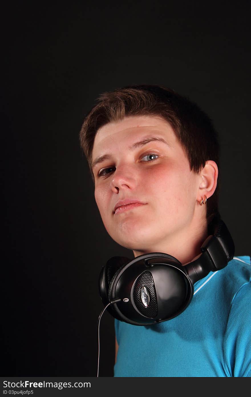 A young boy listening to music on the black background