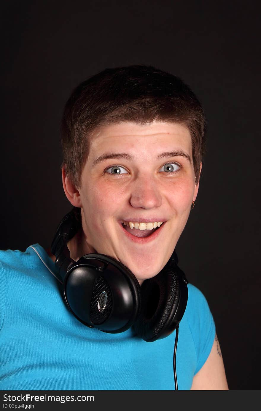 A young boy listening to music on the black background