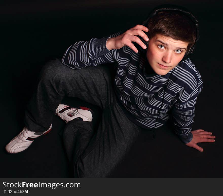 A young boy sitting on the black background