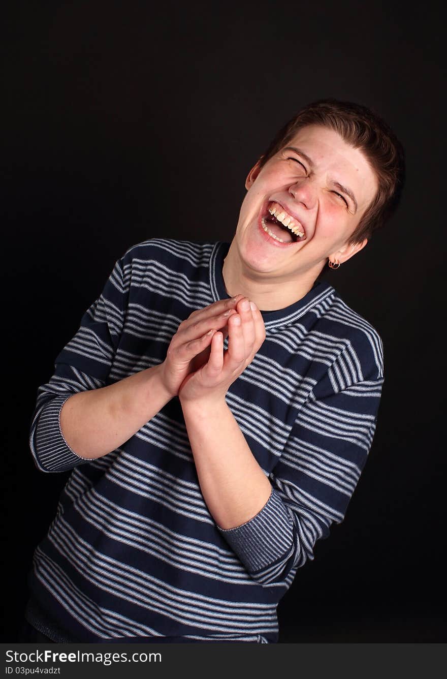 A young boy laughing on the black background