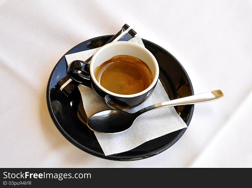 A cup of espresso on a white tablecloth. A cup of espresso on a white tablecloth