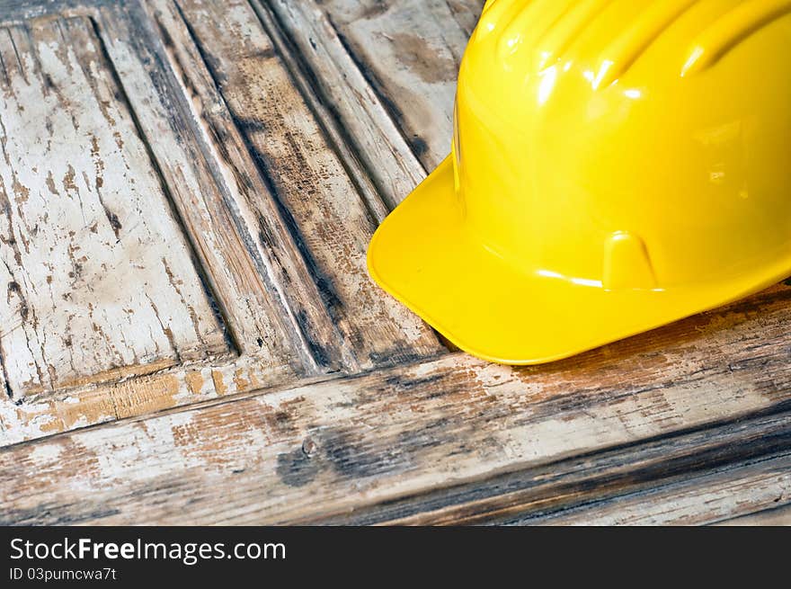 Yellow helmet on burnt wooden log