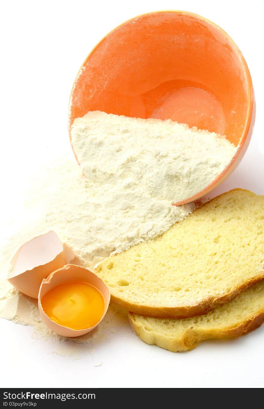 Bowl, flour, bread and eggs on a white background