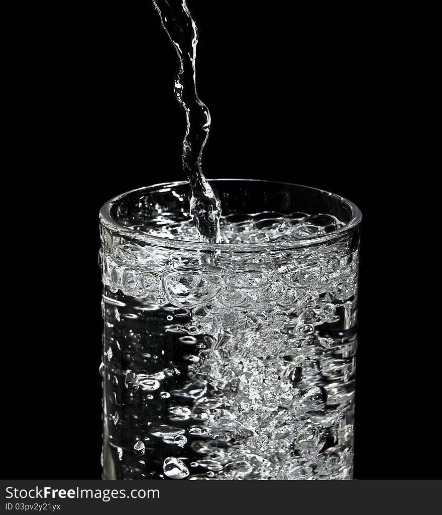 Filling water into glass and black background. Filling water into glass and black background