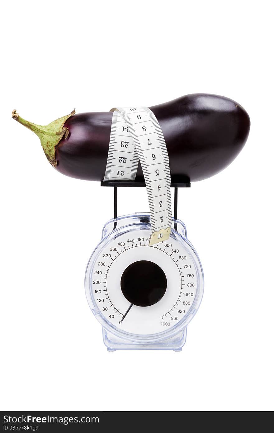 Eggplant with measuring tape on kitchen scale, isolated