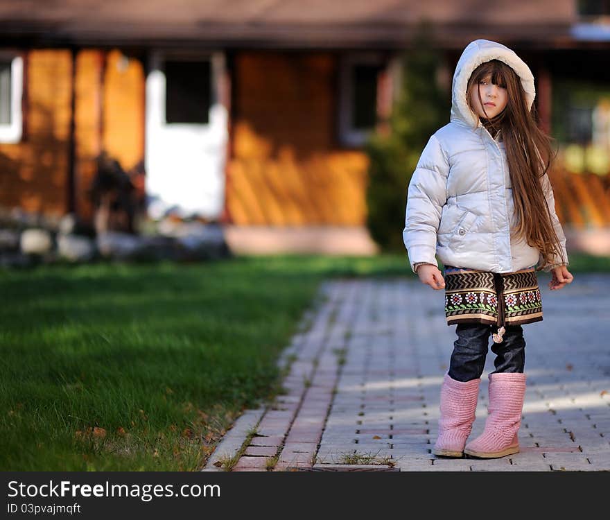 Full length outdoor portrait of adorable child girl with long dark hair in colorful warm clothe. Full length outdoor portrait of adorable child girl with long dark hair in colorful warm clothe