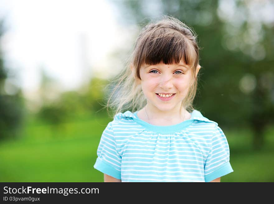 Outdoor portrait of cute child girl in blue jacket