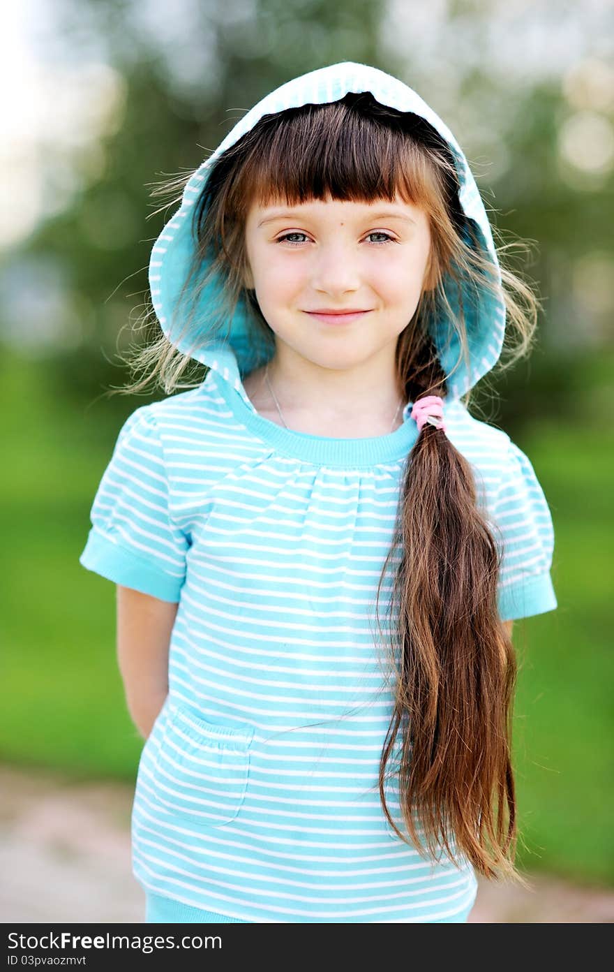 Full length outdoor portrait of adorable child girl in blue jacket with hood. Full length outdoor portrait of adorable child girl in blue jacket with hood