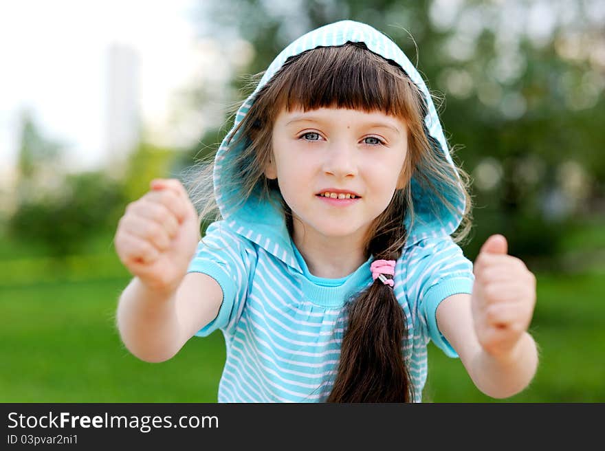 Outdoor portrait of cute child girl in blue jacket