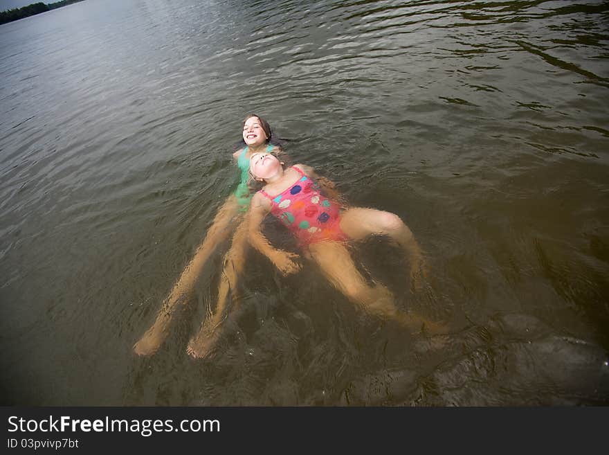 Two smilling girls swimming in lake,. Two smilling girls swimming in lake,