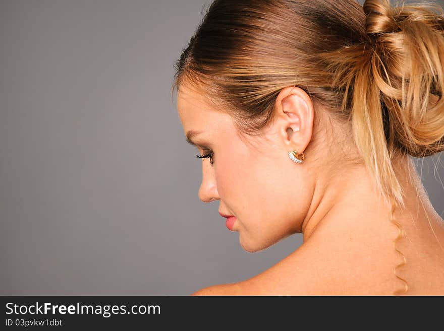 Pretty young woman profile portrait on studio neutral background