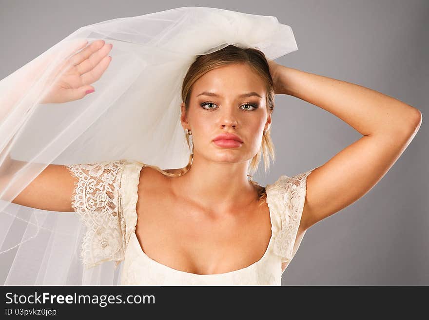 Excited bride earing a veil in studio