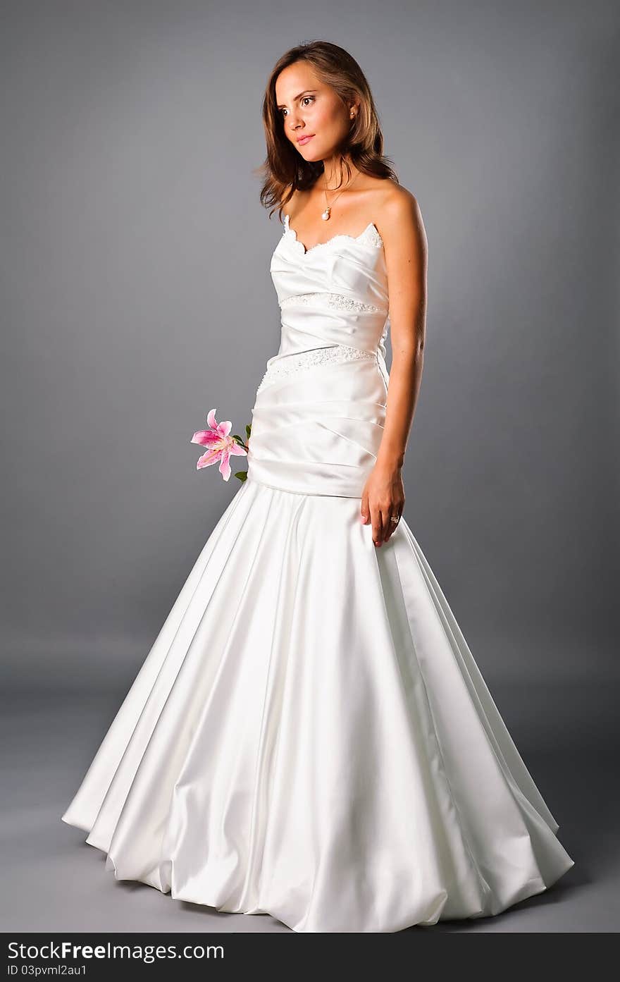 Beautiful bride wearing wedding dress with flower in studio. Beautiful bride wearing wedding dress with flower in studio