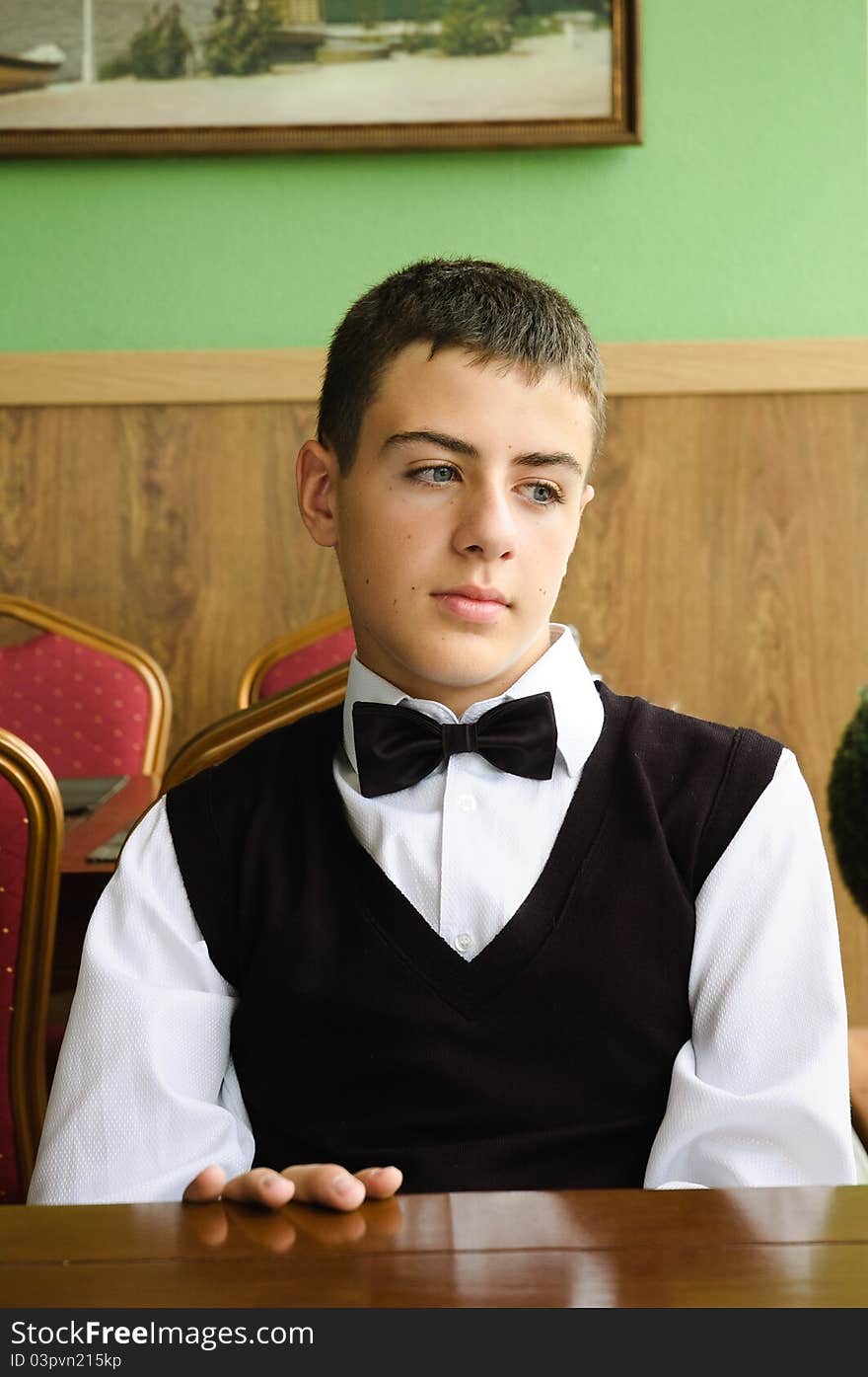 Upset teenager boy waiting for friends in a cafe in morning. Upset teenager boy waiting for friends in a cafe in morning