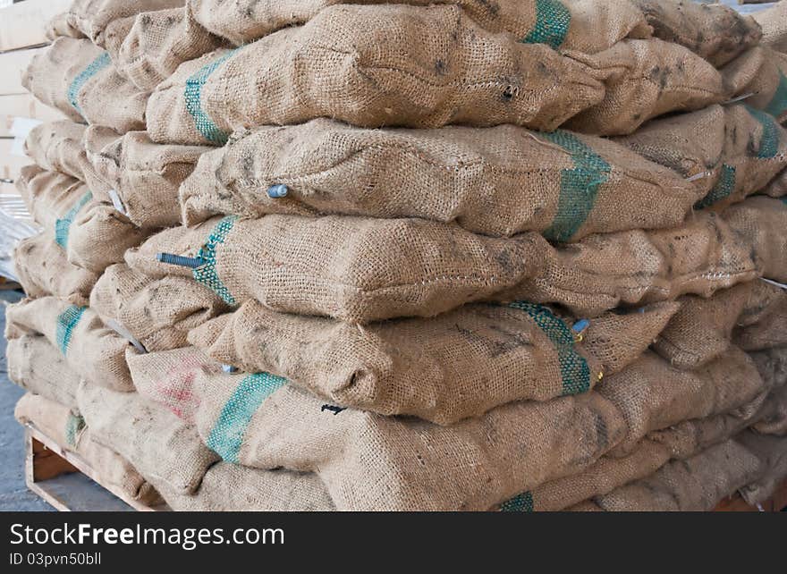 Brown sacks stack on wooden pallet in stockpile tilted. Brown sacks stack on wooden pallet in stockpile tilted