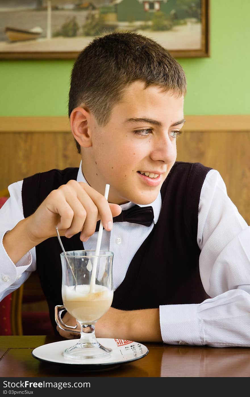 A teenager boy enjoying coffee in a cafe