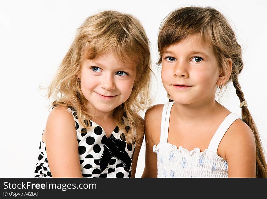 Two smiling little girlfrends isolated on white background. Two smiling little girlfrends isolated on white background