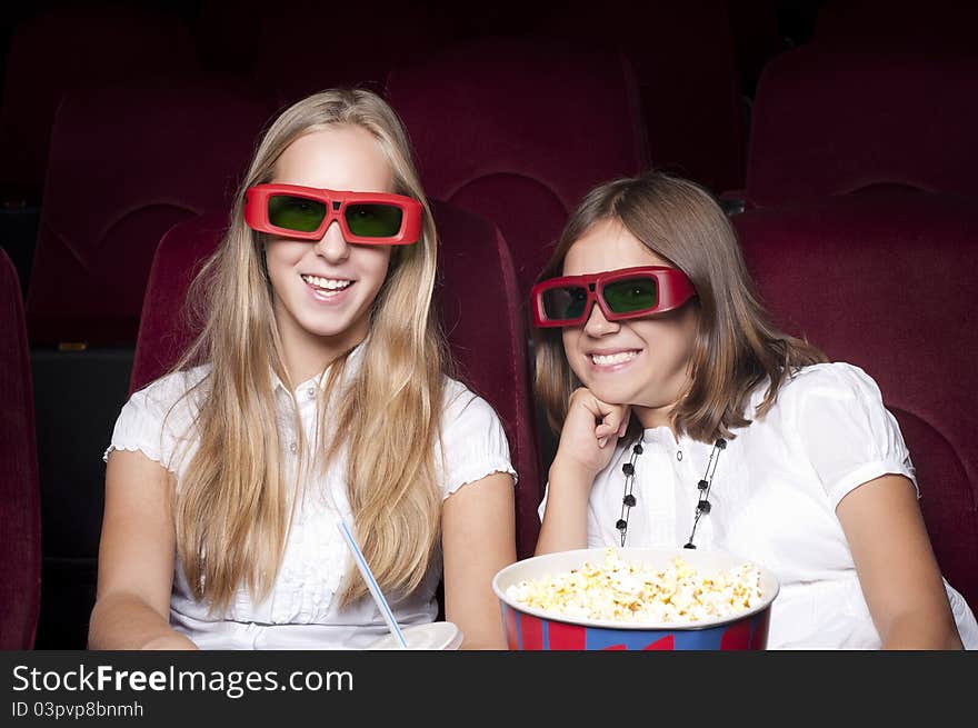 Two Beautiful Girls Watching A Movie At The Cinema