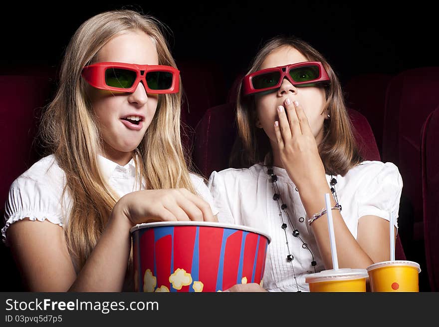 Two Beautiful Girls Watching A Movie At The Cinema