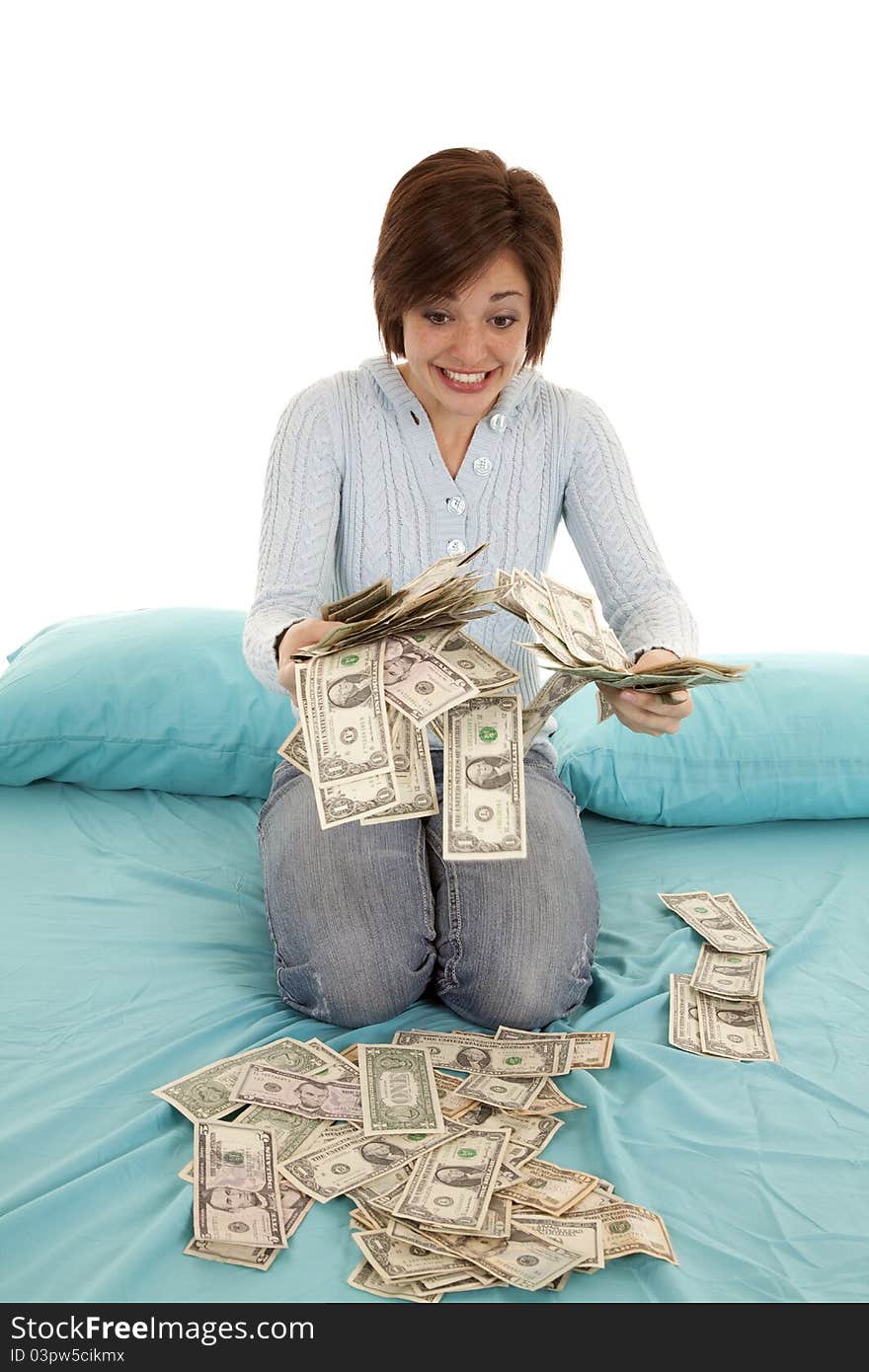 A woman looking at all her money in her hands and bed. A woman looking at all her money in her hands and bed.