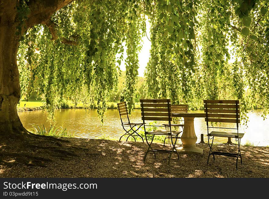 Stone table and chairs next to a pond, spring or summer picture