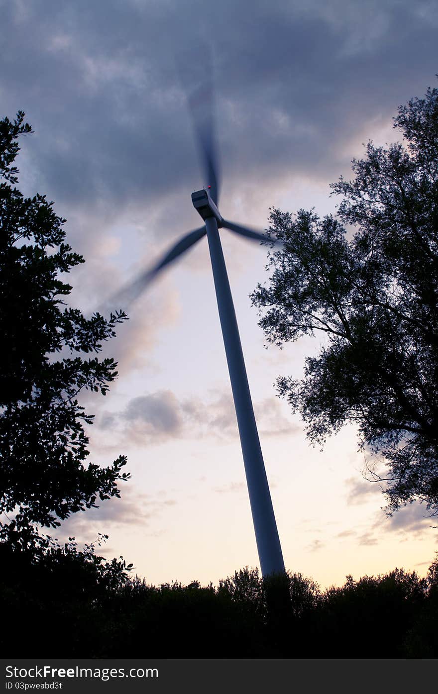 An image of wind turbine at the sunset