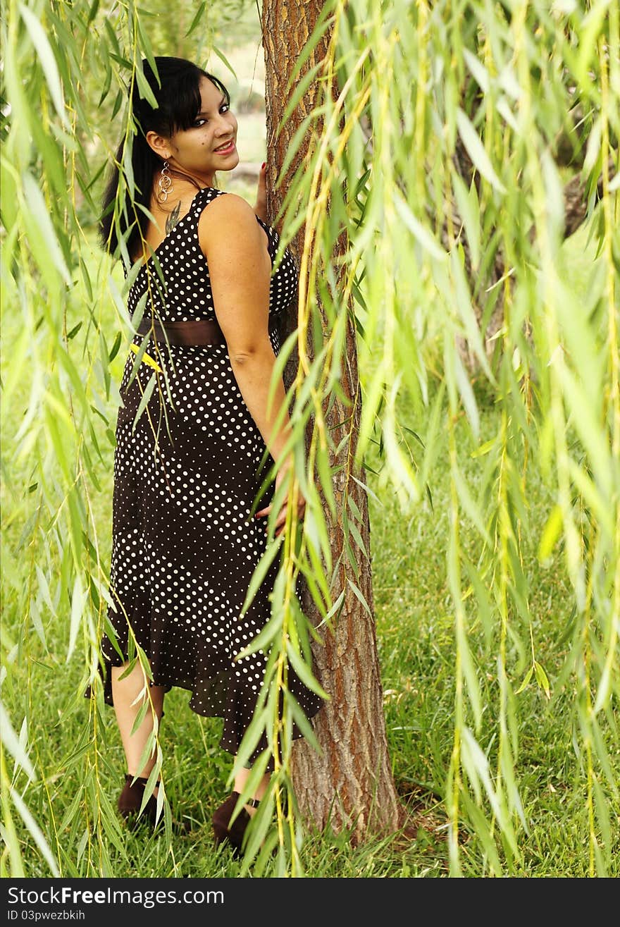 Portrait of a pretty woman posing under a weeping willow tree. Portrait of a pretty woman posing under a weeping willow tree.