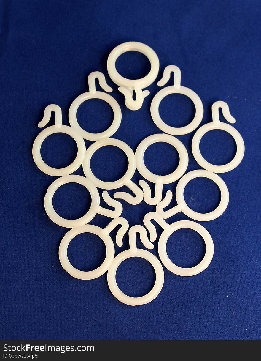 Designing of white plastic curtain rings on blue background. Designing of white plastic curtain rings on blue background