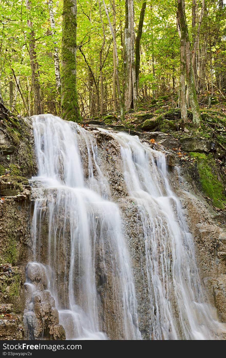 Waterfall with a stream in the deciduous forest