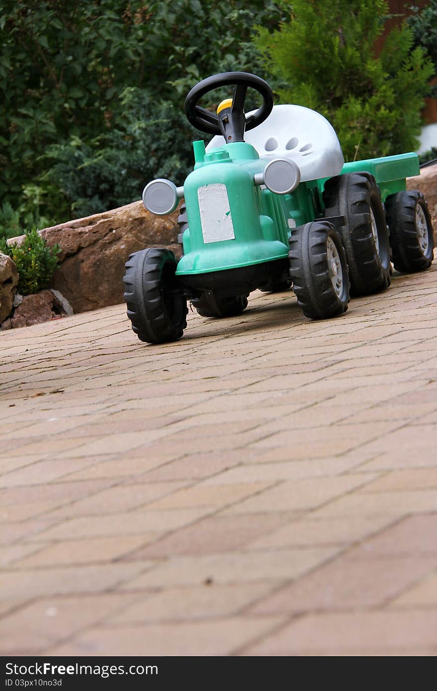 Green tractor toy on the garden terrace