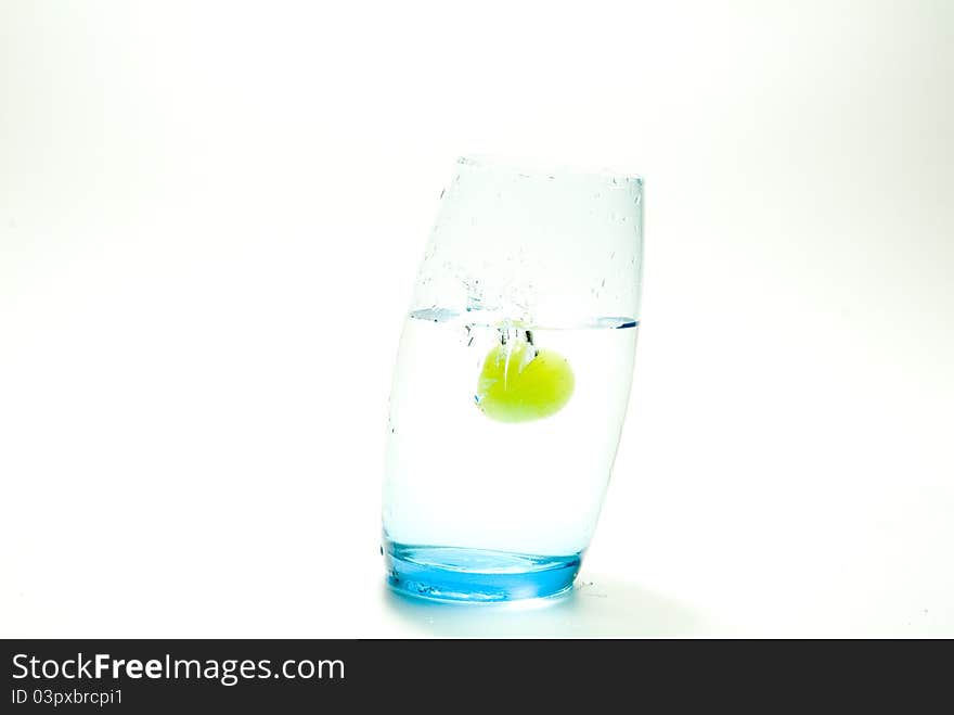 Grape splashing in a glass of water