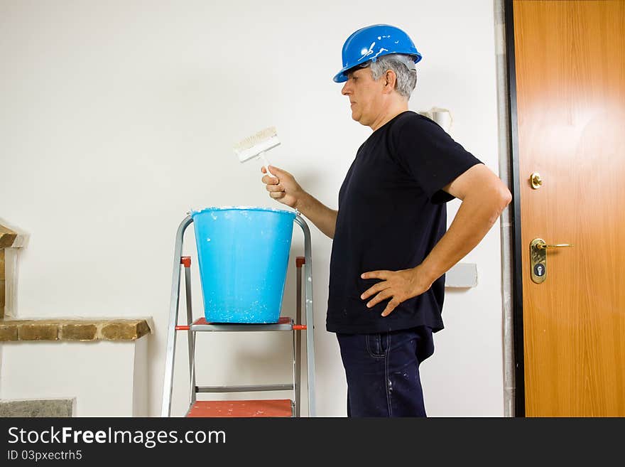 House painter at work in a house painting a wall