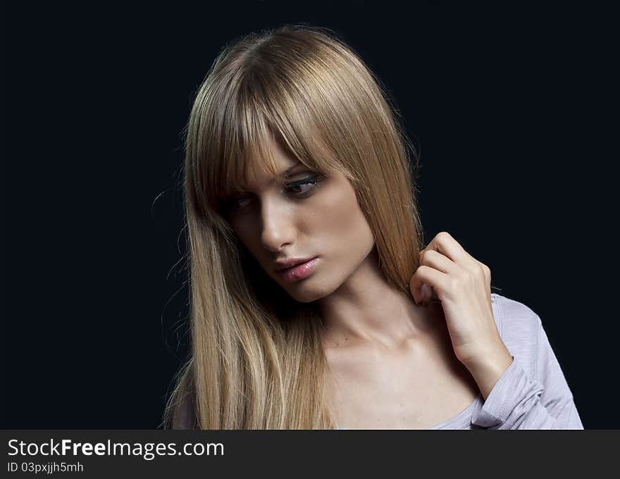 A portrait of a young blond woman isolated on black background. A portrait of a young blond woman isolated on black background