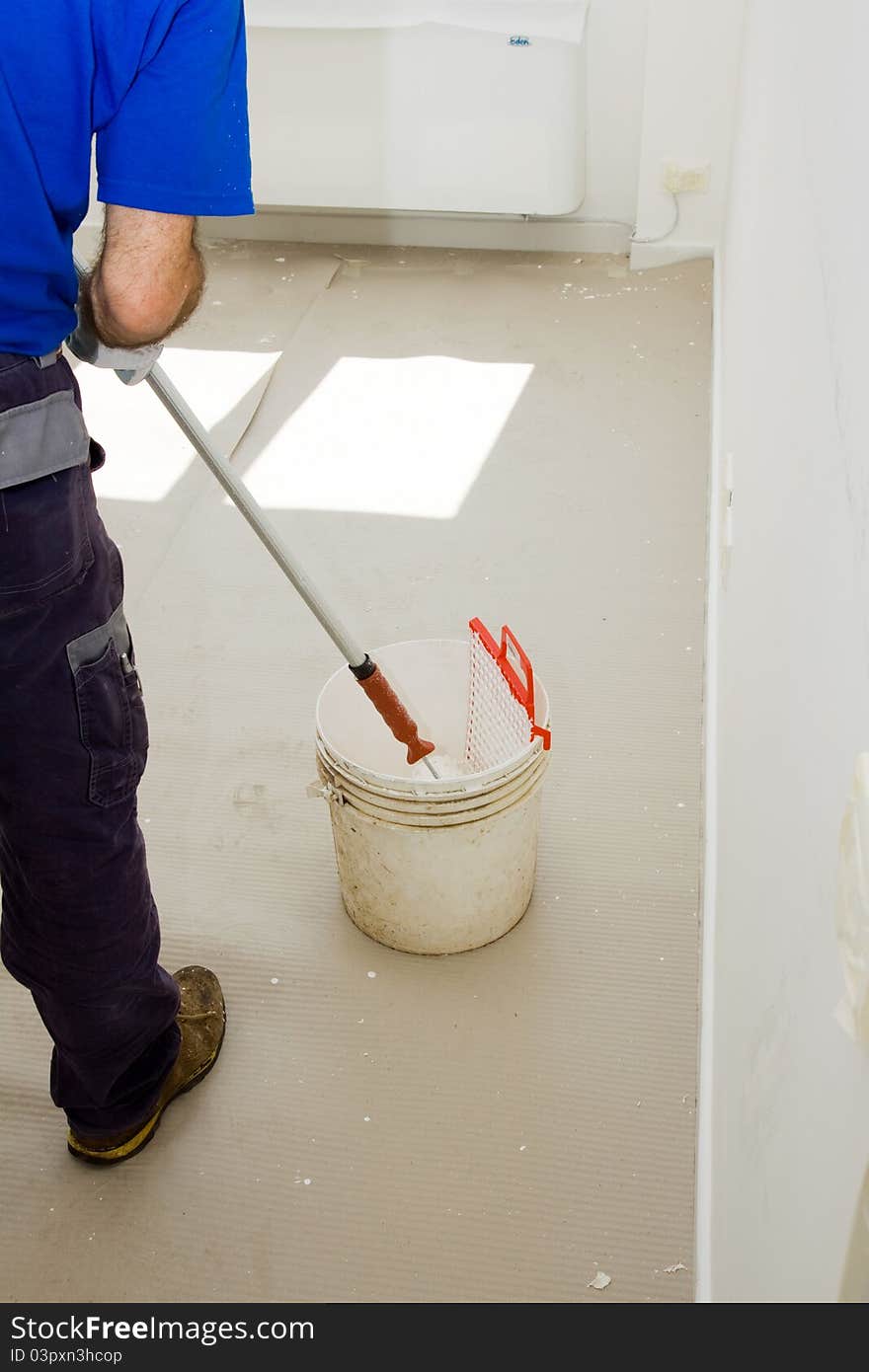 House painter using the roller for the walls of the room