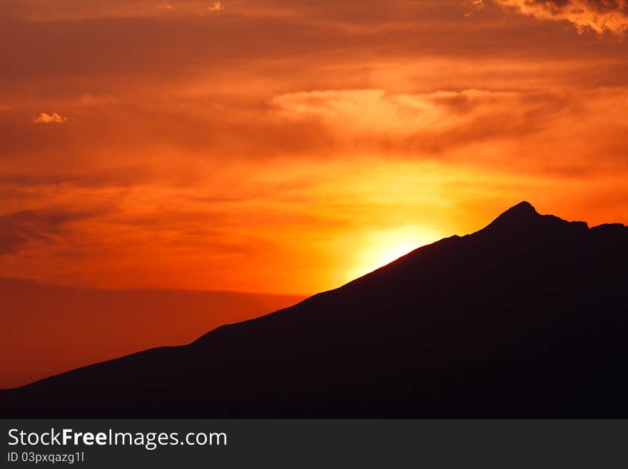 Clouded orange sky with mountain silhouette