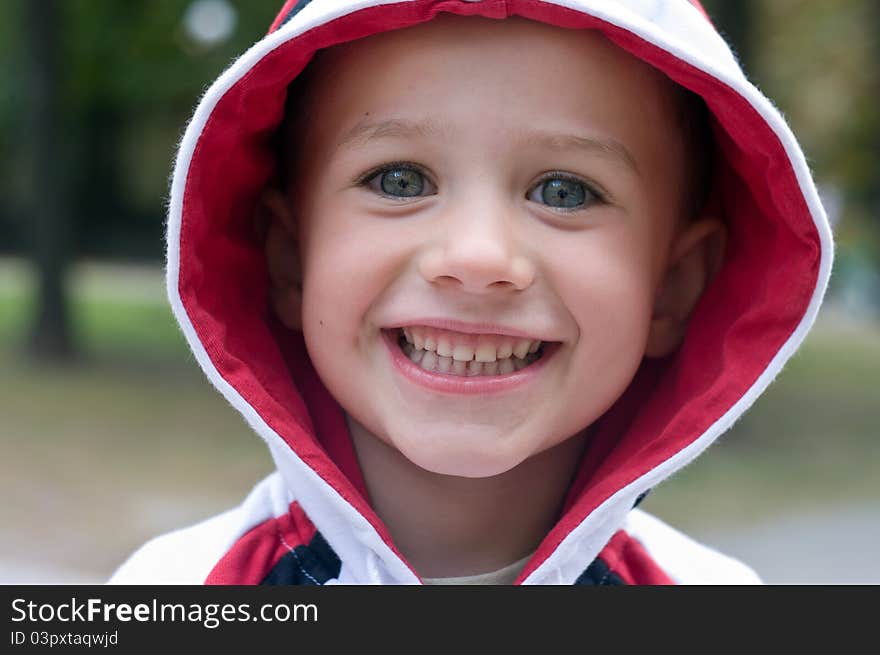 A portrait of a smiling boy in a hood