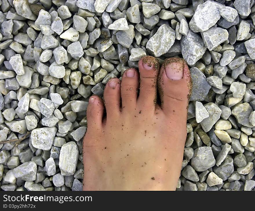 Foot with sand and stone