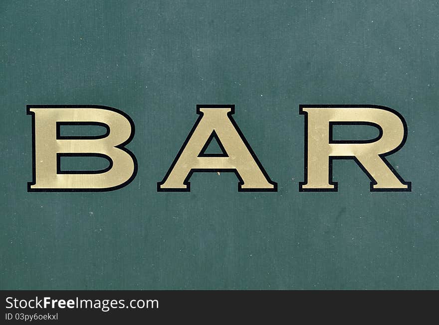 Golden Bar sign painted on green wall