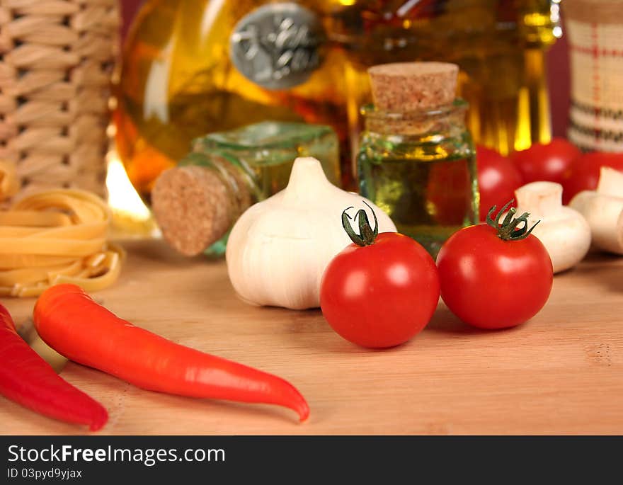 Fresh vegetables, macaroni and olive oil on table