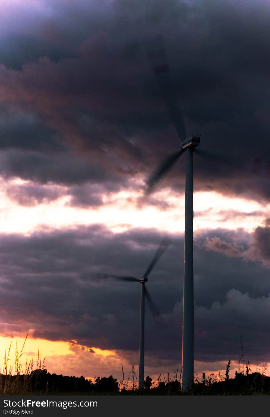 An image of wind turbine at the sunset