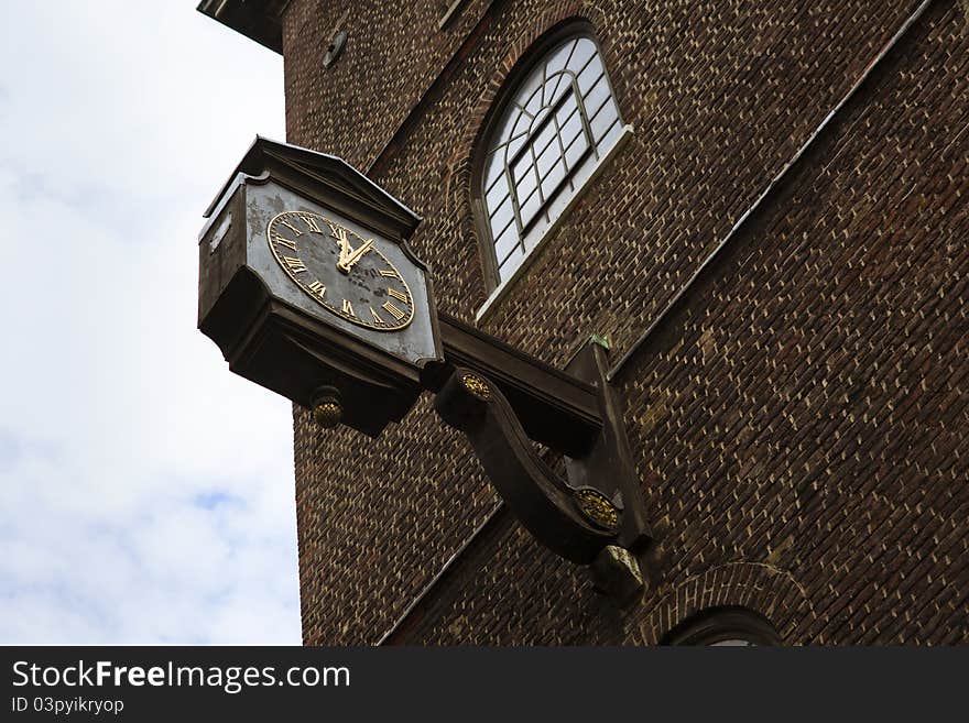 Large aged clock attached to the wall. Large aged clock attached to the wall