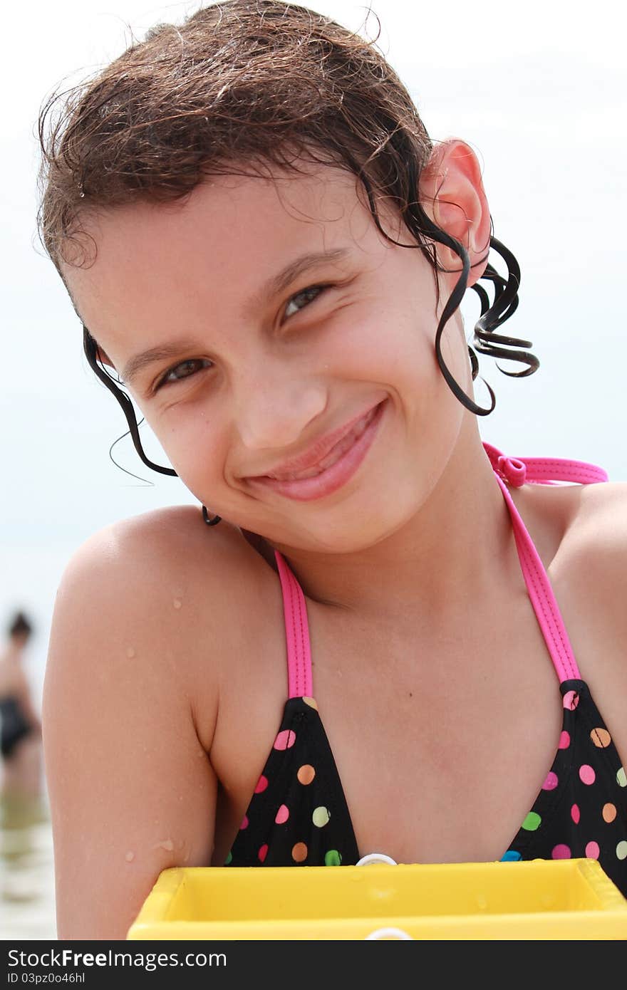 A Girl at the bea with a yellow beach bucket. A Girl at the bea with a yellow beach bucket