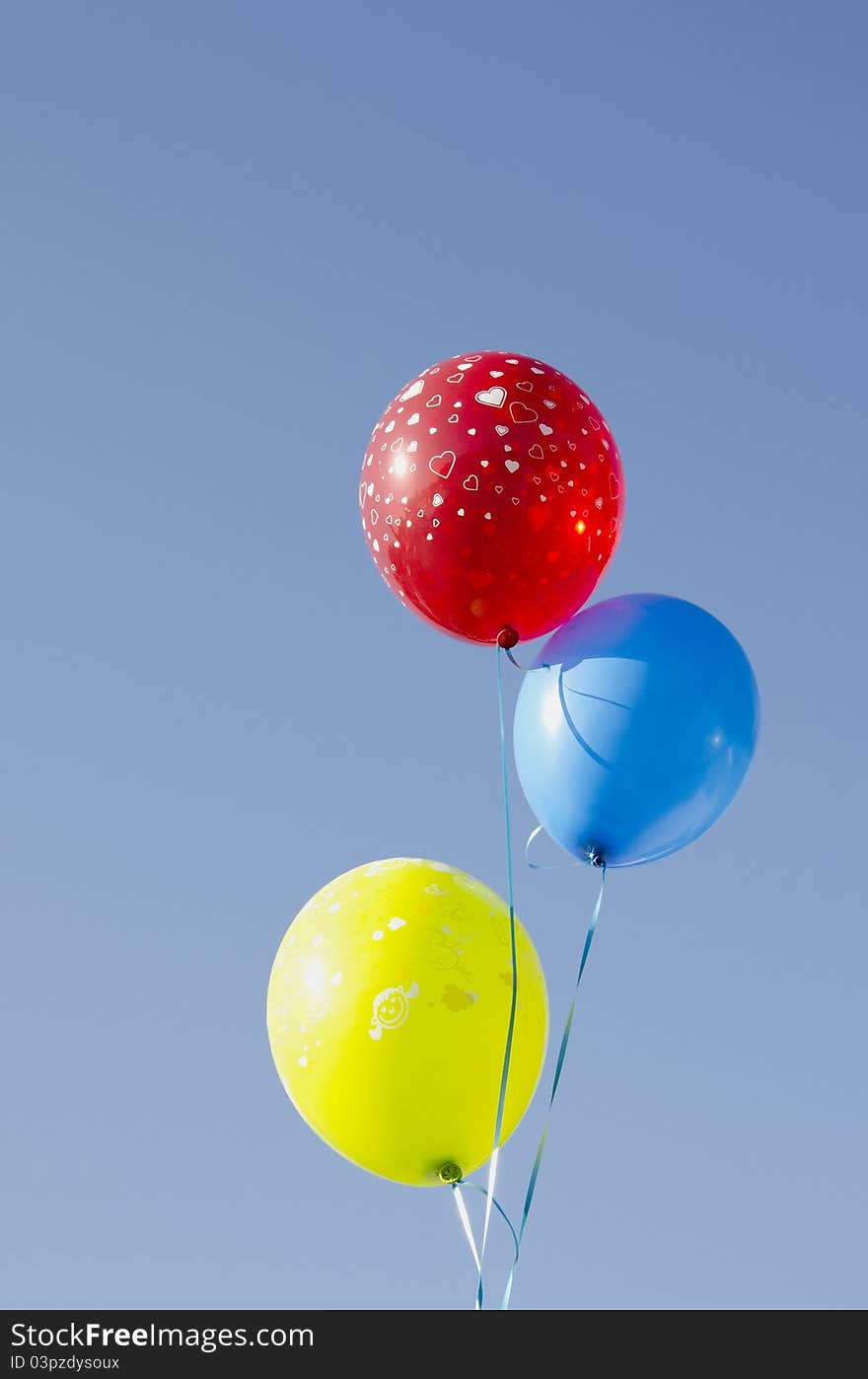 Multicolor balloons tied with strings.