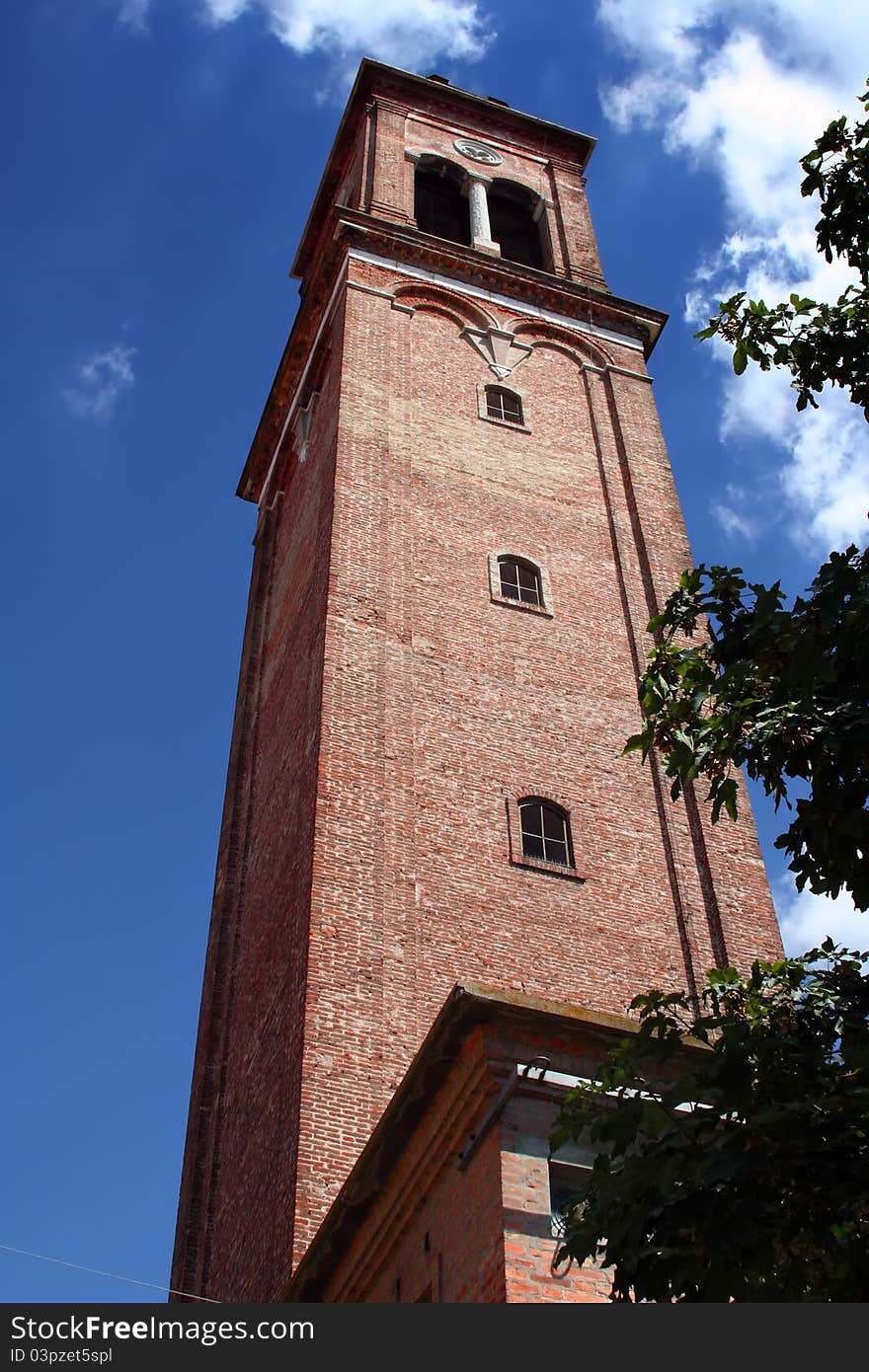 A bell tower of bricks on blue sky