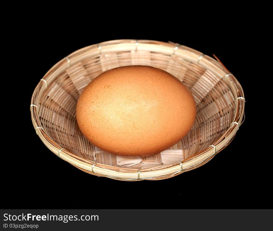 Egg in a basket on black background