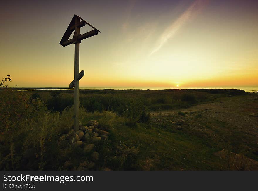 Old wooden cross on a sunset