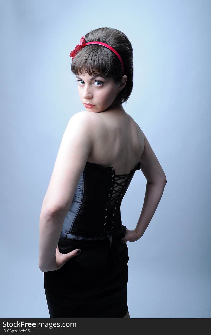 Woman is back in a black corset, looking. Woman is back in a black corset, looking