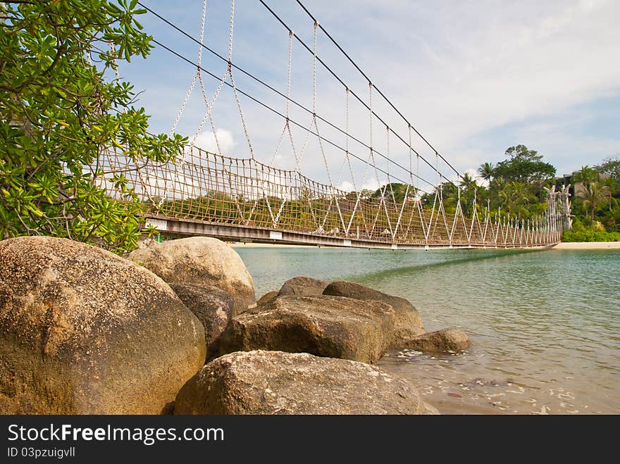 Low hanging wooden bridge connecting to beautiful uninhabited island. Low hanging wooden bridge connecting to beautiful uninhabited island.